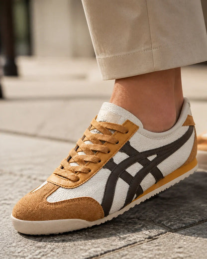 Close construction detail of brown-yellow retro panel sneakers.
